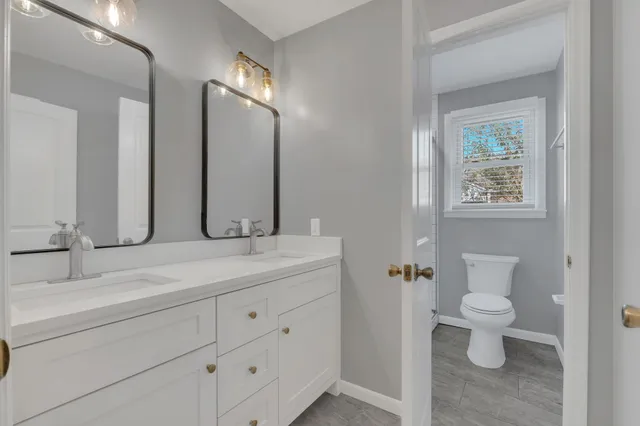 a bathroom with a toilet sink and mirror