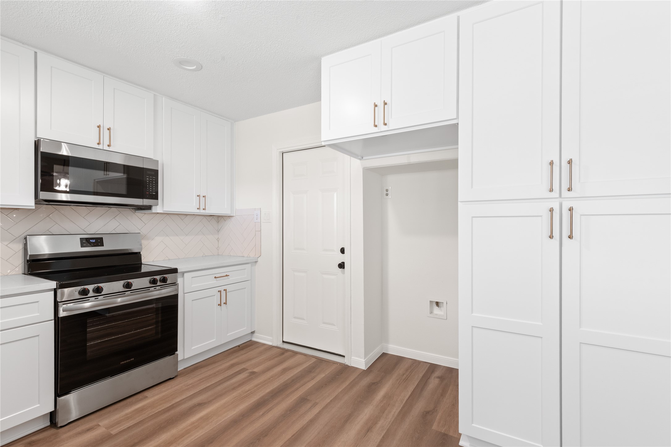 907 Avenue B Sweeny, TX 77480 - Photo 13 of 23 a kitchen with cabinets stainless steel appliances and wooden floor