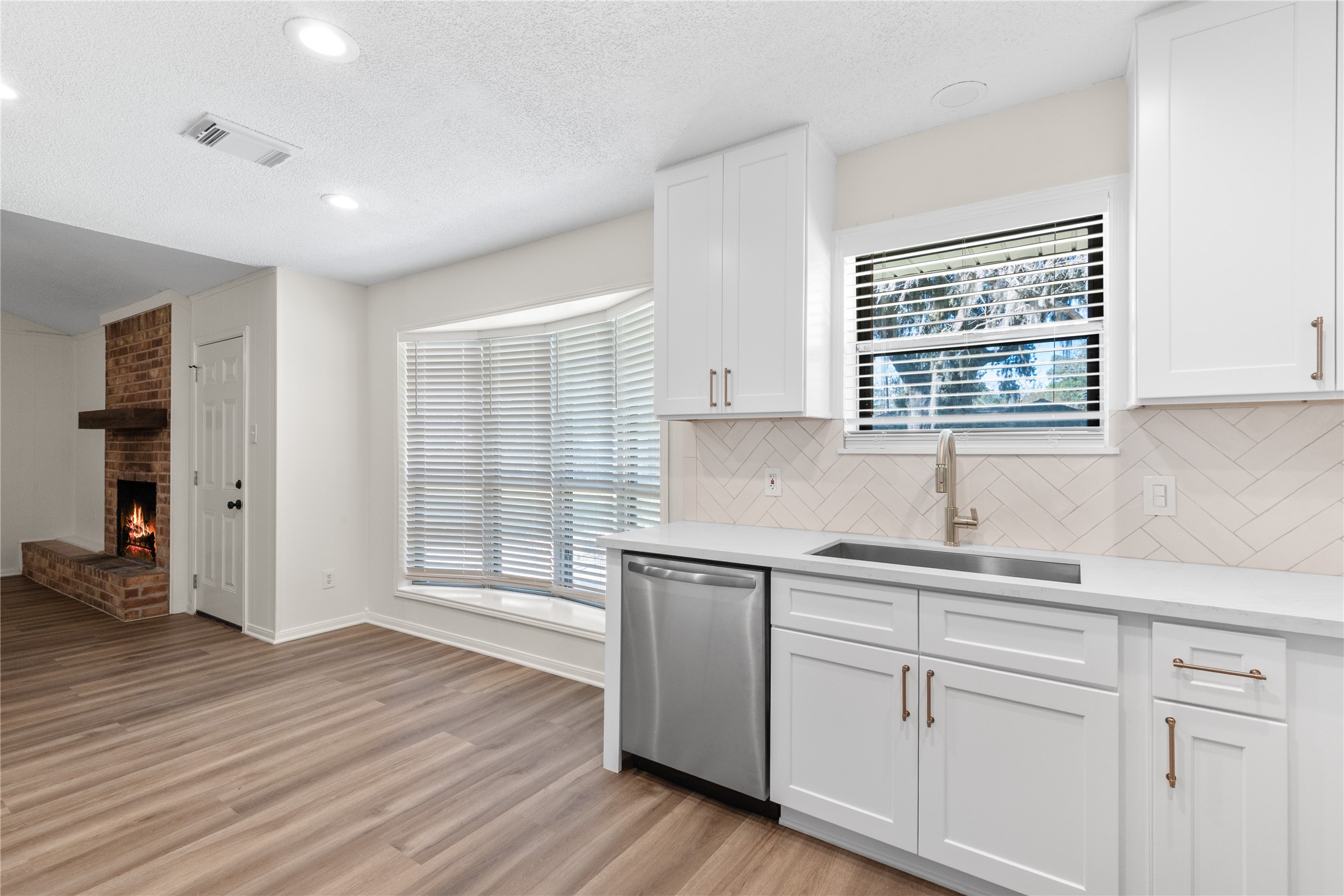 907 Avenue B Sweeny, TX 77480 - Photo 14 of 23 a kitchen with a sink cabinets stainless steel appliances and windows