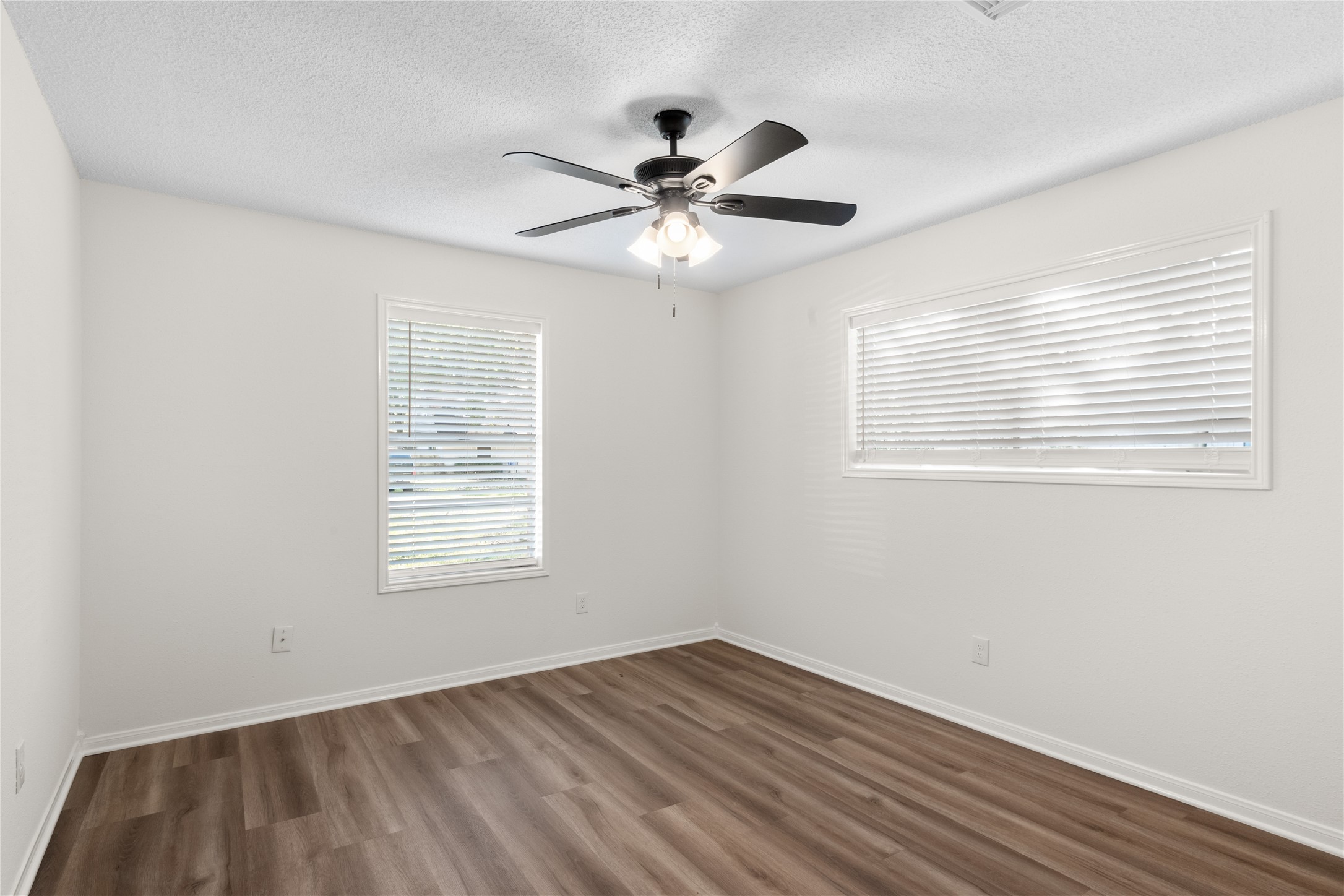 907 Avenue B Sweeny, TX 77480 - Photo 18 of 23 a view of an empty room with wooden floor and a window