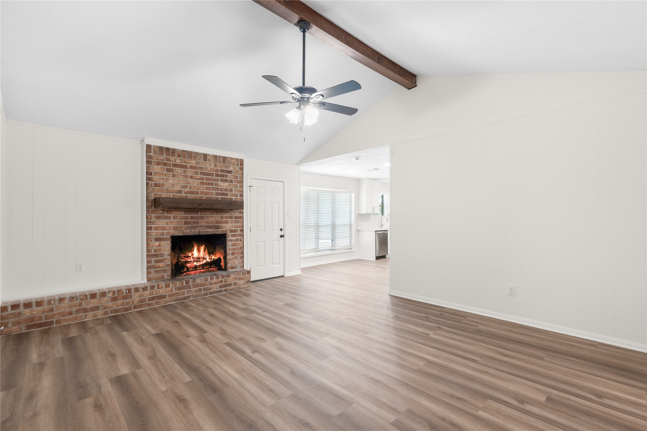 907 Avenue B Sweeny, TX 77480 - Photo 5 of 23 a view of an empty room with wooden floor a fireplace and a window