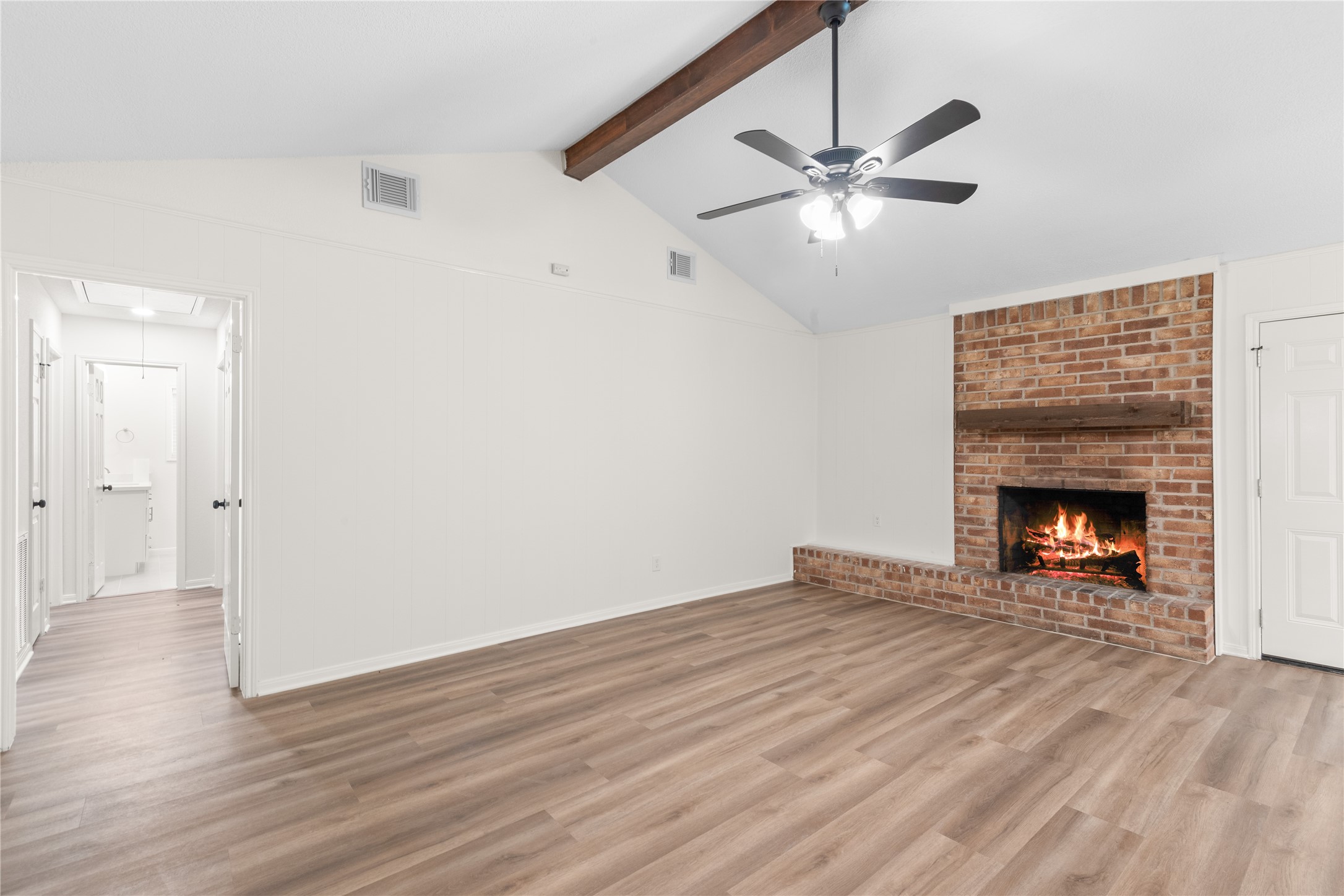 907 Avenue B Sweeny, TX 77480 - Photo 6 of 23 a view of an empty room with wooden floor a fireplace and a window