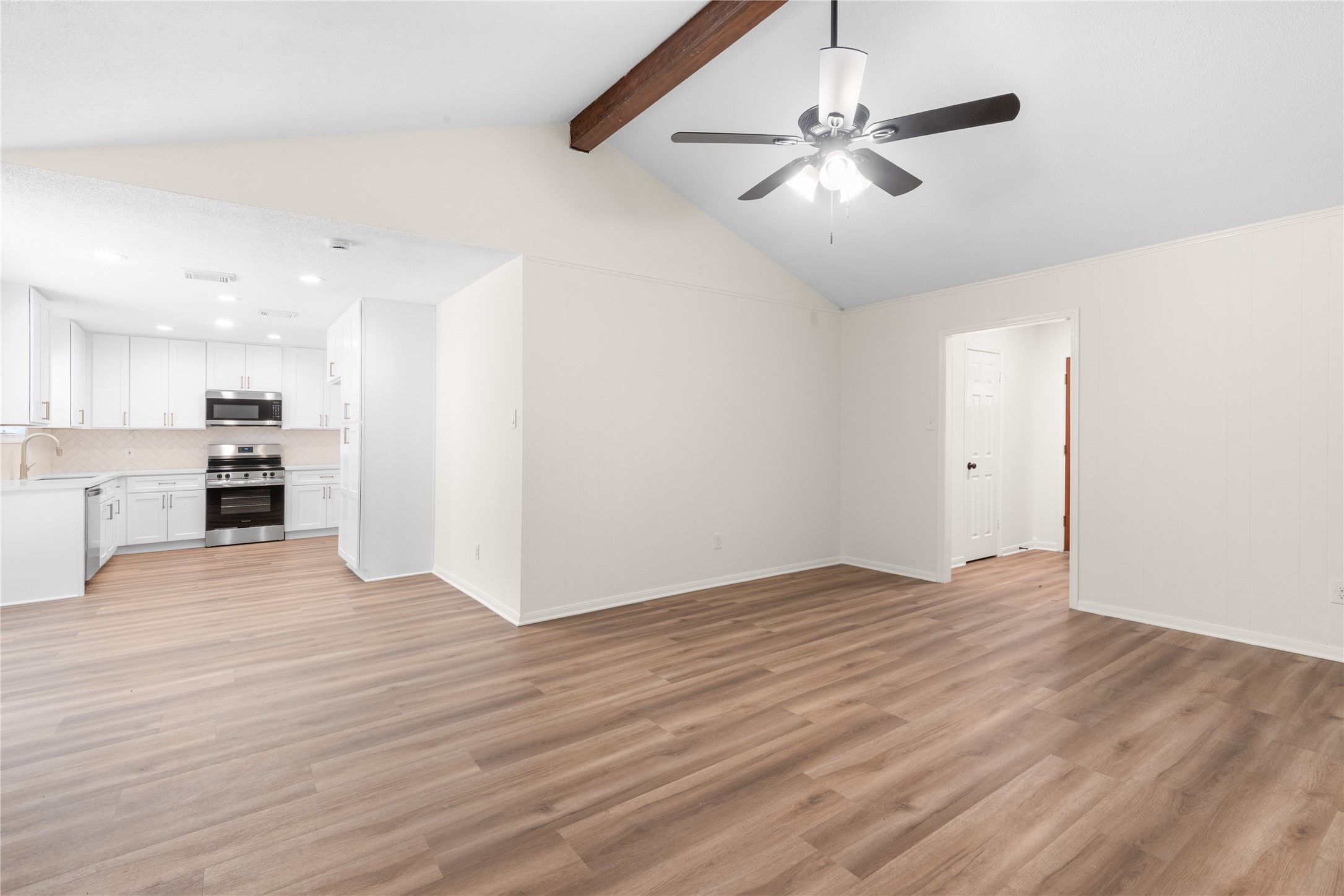 907 Avenue B Sweeny, TX 77480 - Photo 7 of 23 a view of an empty room with wooden floor and a ceiling fan
