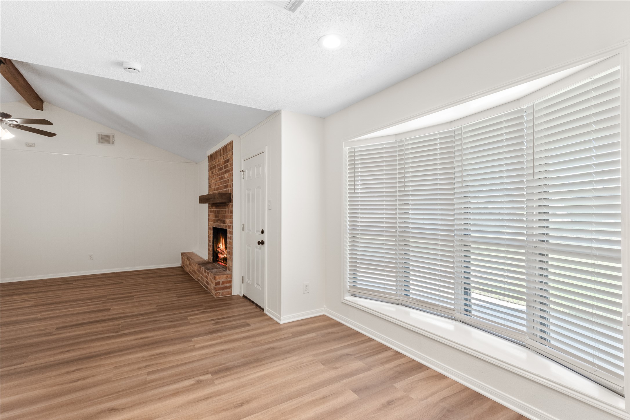 907 Avenue B Sweeny, TX 77480 - Photo 8 of 23 an empty room with wooden floor and windows