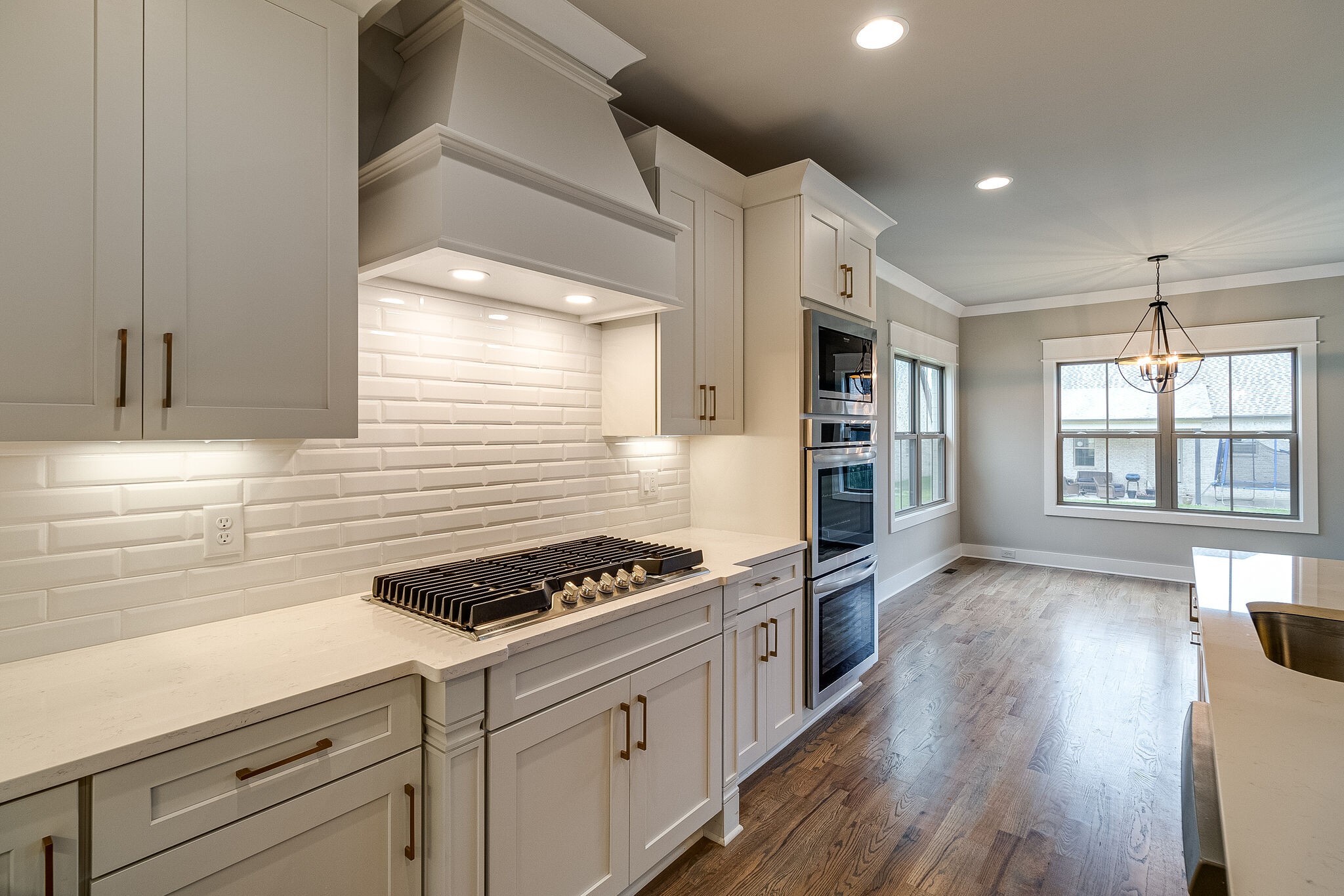 1028 Gadwall Lane Spring Hill, TN 37174 - Photo 14 of 40 a kitchen with granite countertop a stove a sink dishwasher and white cabinets with wooden floor