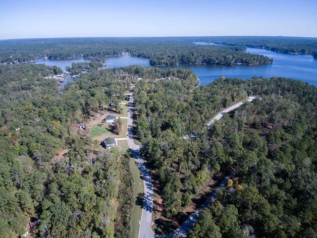 an aerial view of a house with a yard and lake view