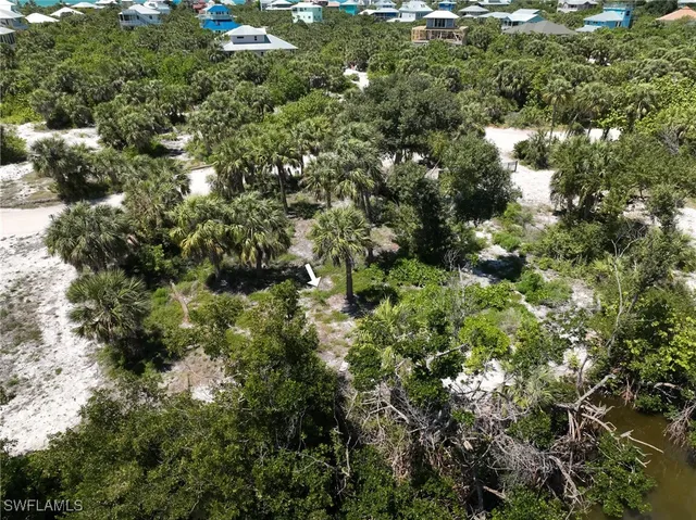 an aerial view of residential house with outdoor space and trees all around