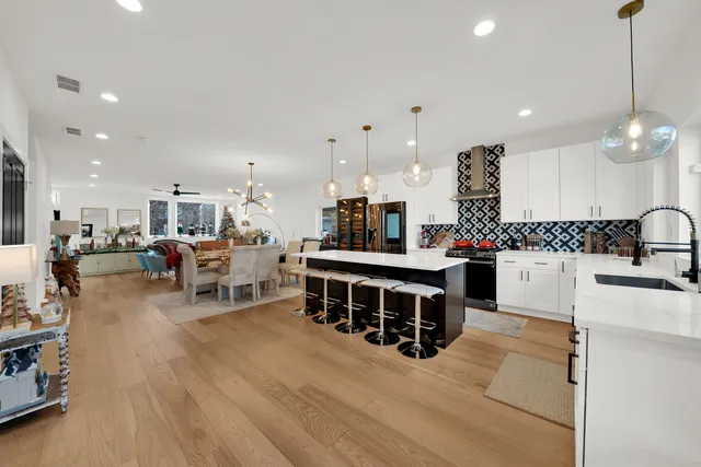 a kitchen with stainless steel appliances kitchen island granite countertop a sink and a refrigerator