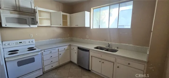 a kitchen with white cabinets and sink