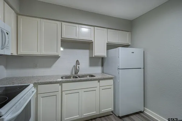 a kitchen with cabinets and white appliances