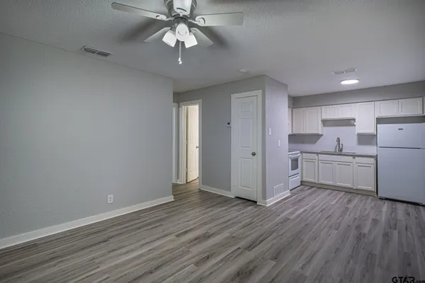 a view of a kitchen with wooden floor and a ceiling fan