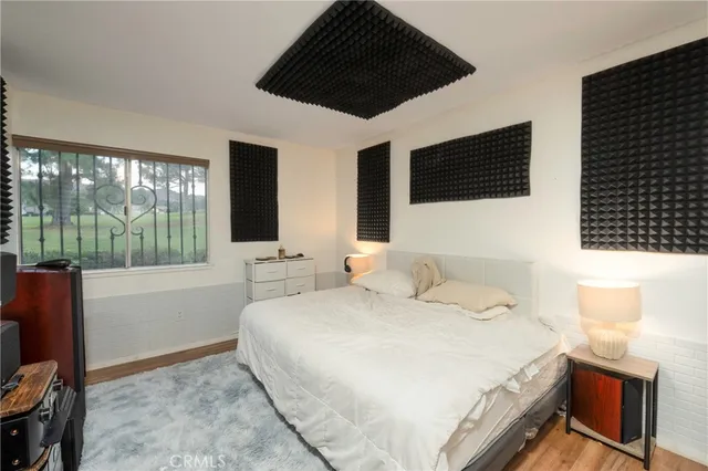 a bedroom with a large bed and a flat tv screen on dresser
