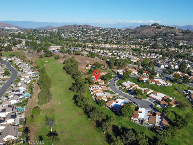 an aerial view of residential houses with outdoor space and trees
