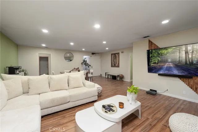 a living room with furniture and a wooden floor