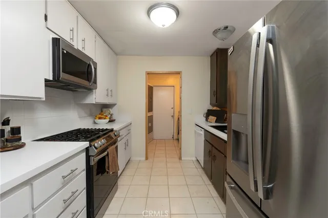 a kitchen with stainless steel appliances granite countertop a stove top oven a sink and dishwasher