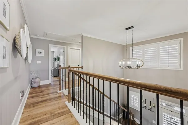 a view of a hallway with wooden floor and staircase