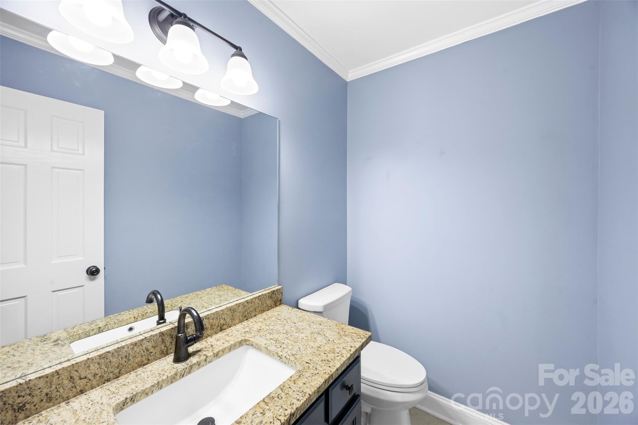 813 Rothmoor Drive Northeast Concord, NC 28025 - Photo 14 of 35 a bathroom with a granite countertop sink a toilet and a mirror