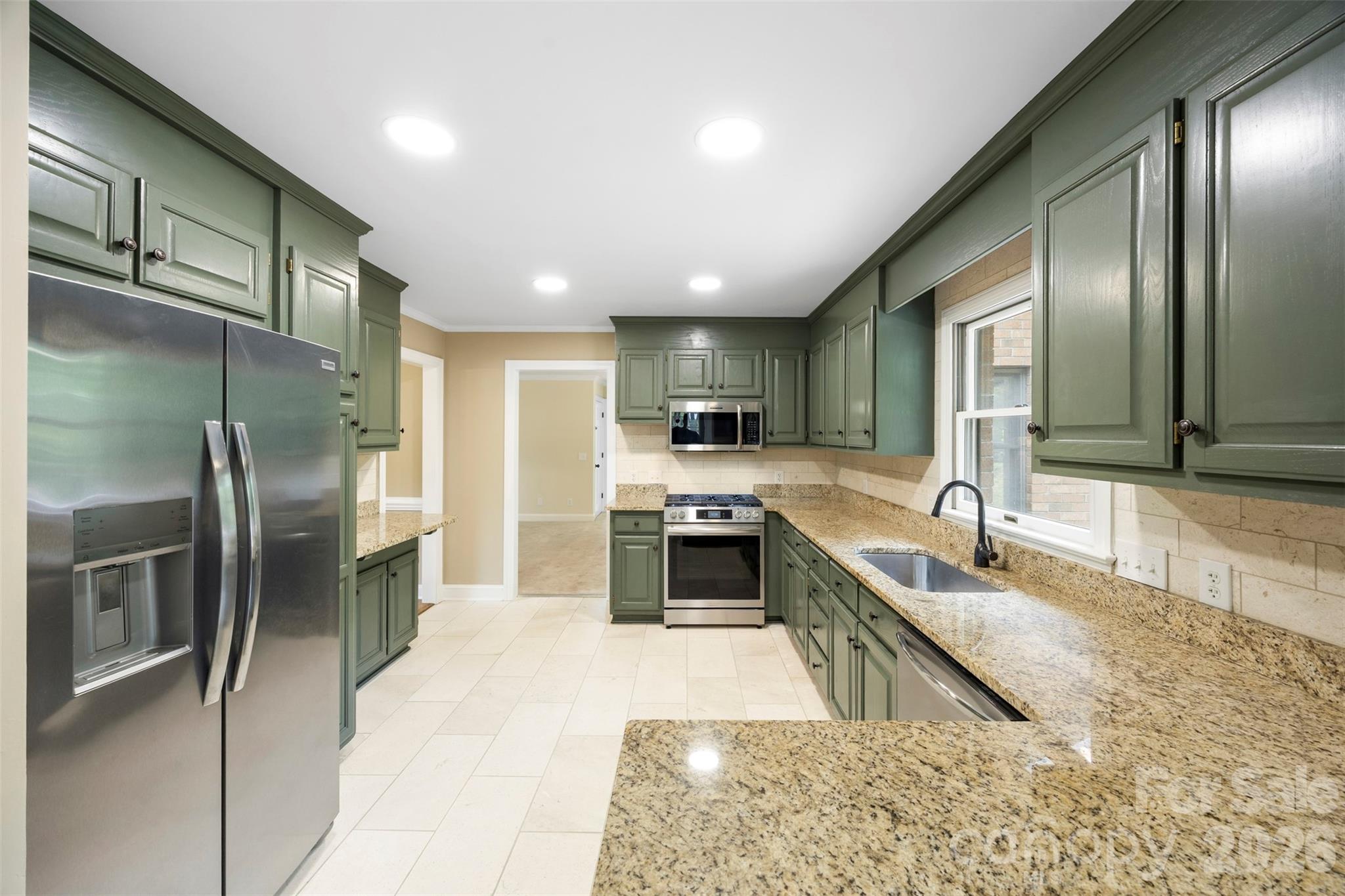 813 Rothmoor Drive Northeast Concord, NC 28025 - Photo 5 of 35 a large kitchen with stainless steel appliances kitchen island granite countertop a refrigerator a sink a stove a washer dryer and a refrigerator