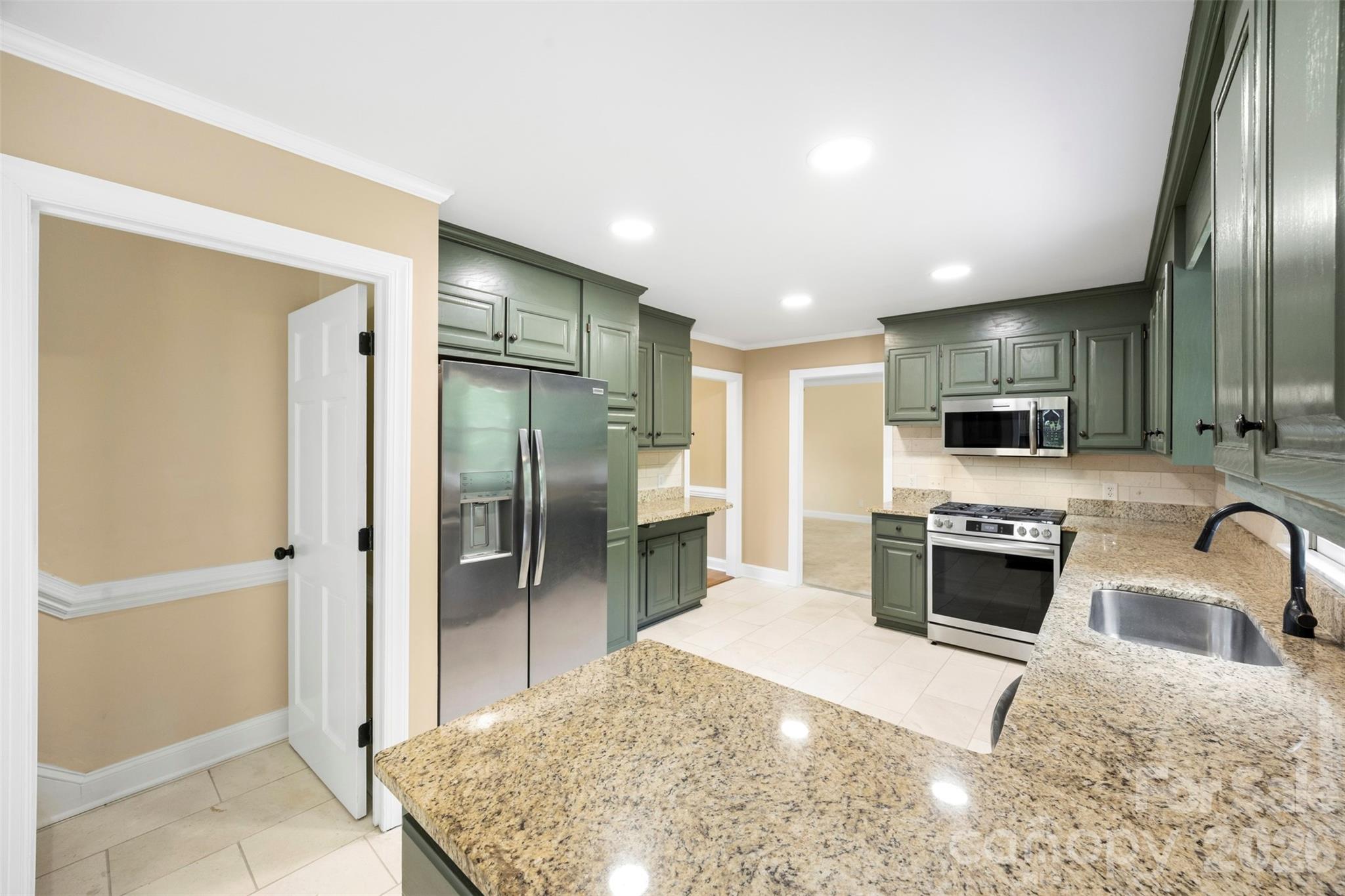 813 Rothmoor Drive Northeast Concord, NC 28025 - Photo 6 of 35 a kitchen with stainless steel appliances granite countertop a refrigerator a stove and a sink