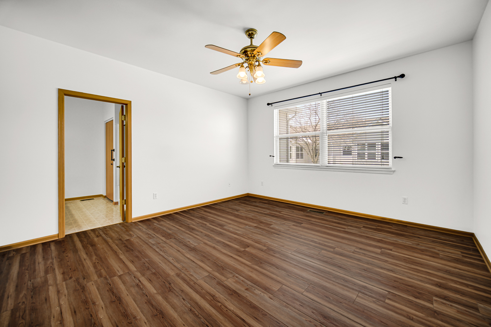 690 Wellston Lane Romeoville, IL 60446 - Photo 12 of 22 a view of an empty room with wooden floor and a window
