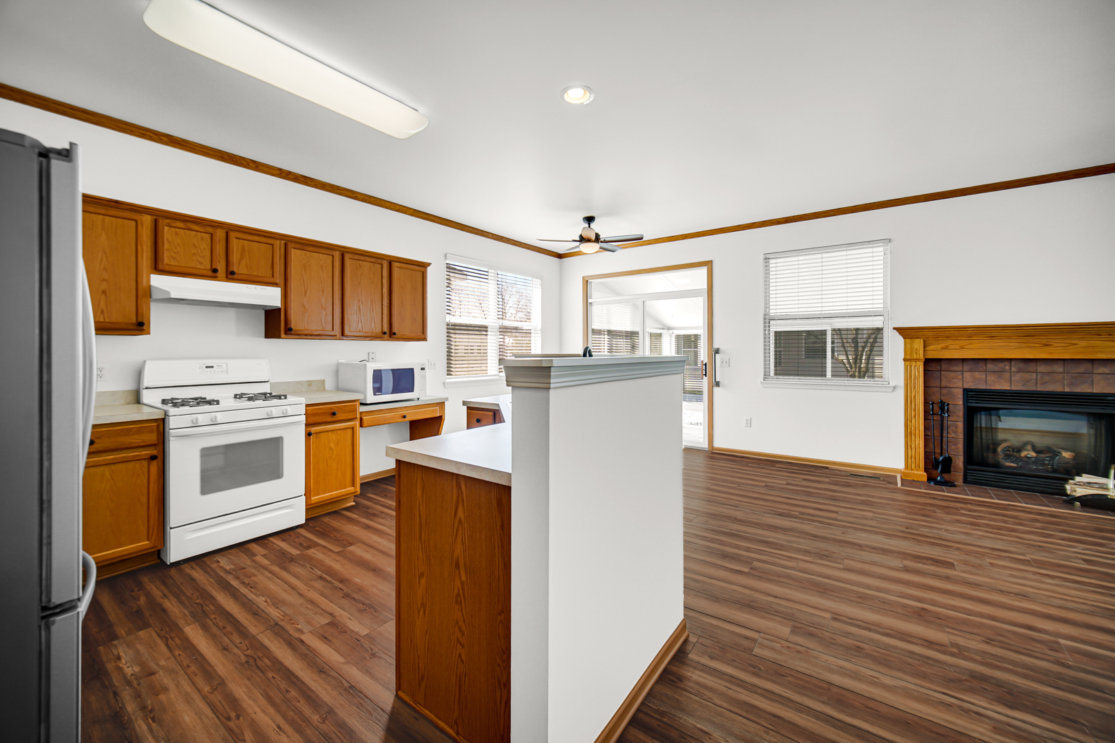 690 Wellston Lane Romeoville, IL 60446 - Photo 5 of 22 a kitchen with stainless steel appliances a stove top oven a sink dishwasher and a refrigerator with wooden floor