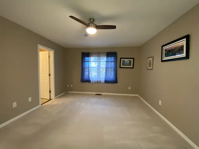 an empty room with windows and mirror fan