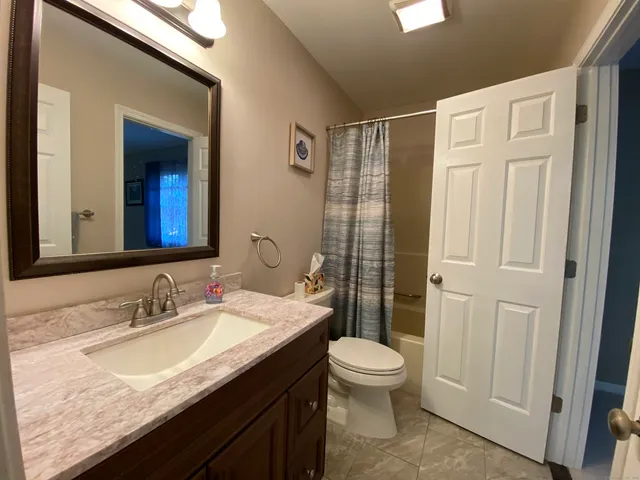 a view of a livingroom with a chandelier fan and windows