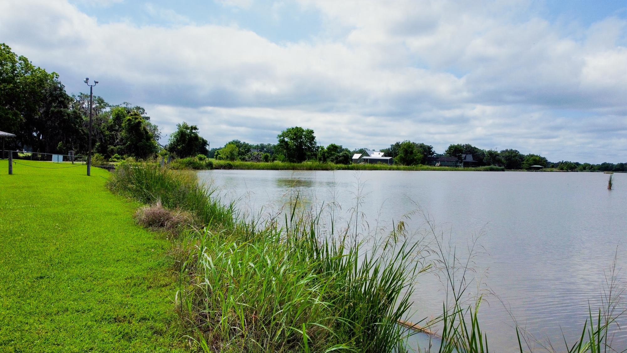 118 Pony Trail Angleton, TX 77515 - Photo 13 of 20 a view of a lake with houses in back