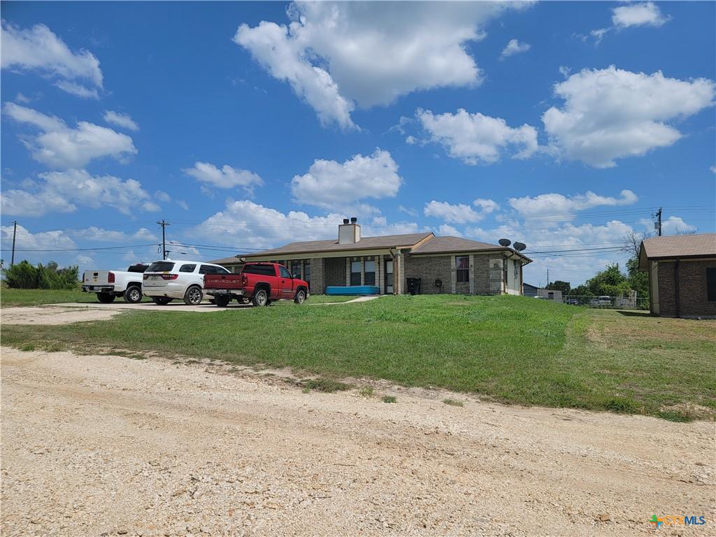 A sprawling brick ranch with a classic chimney, offering abundant outdoor space.
