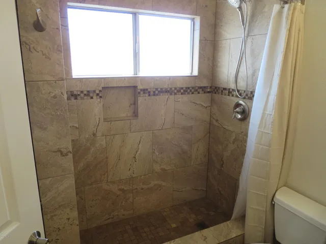a bathroom with a shower and a window