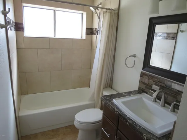 a bathroom with a sink toilet mirror and bathtub