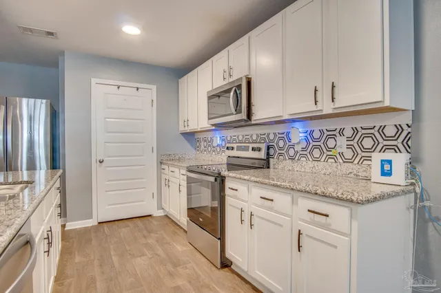 a kitchen with stainless steel appliances granite countertop a sink and a stove top oven