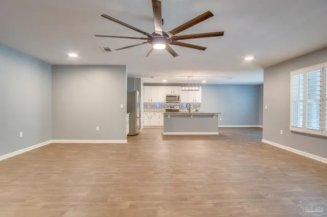 a view of a livingroom with a ceiling fan and kitchen floor