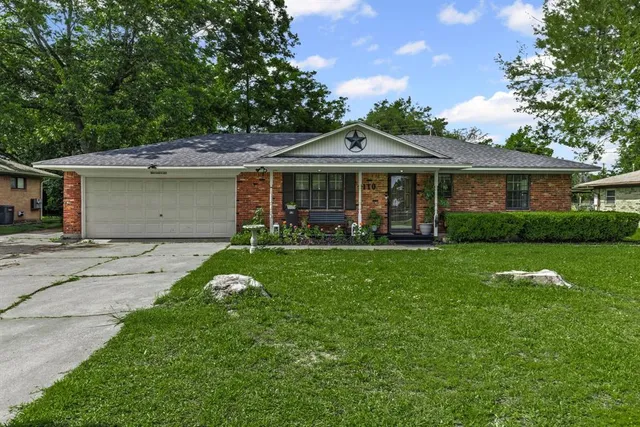 a front view of a house with a yard and potted plants