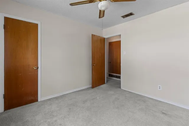 an empty room with a empty space and a ceiling fan