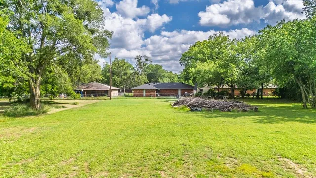 an aerial view of residential houses with outdoor space and trees