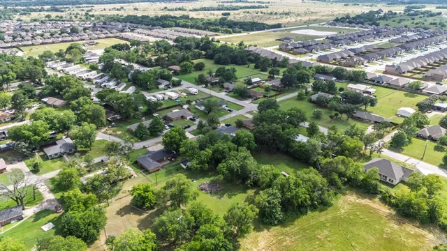 an aerial view of residential houses with outdoor space and trees