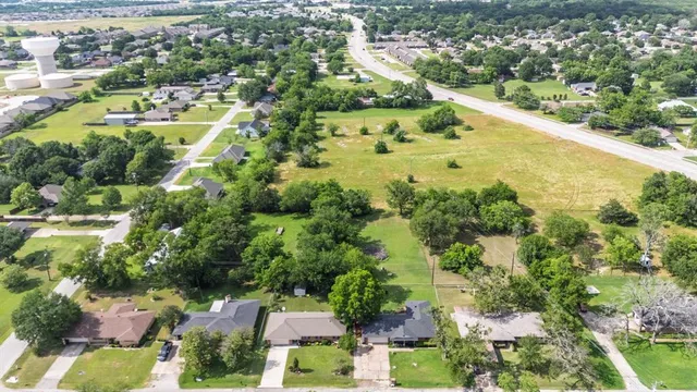 an aerial view of residential house with outdoor space and trees all around