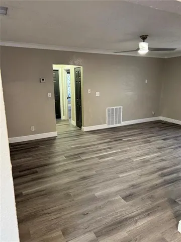 a view of an empty room with wooden floor