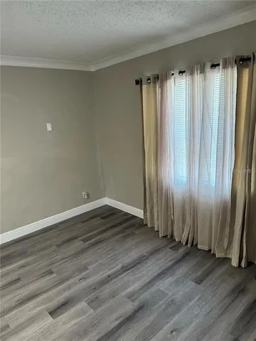 an empty room with wooden floor and a window