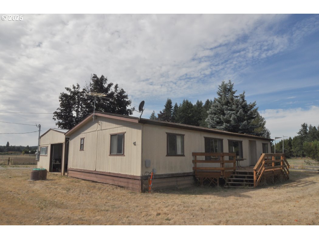 a view of house with a big yard and large trees