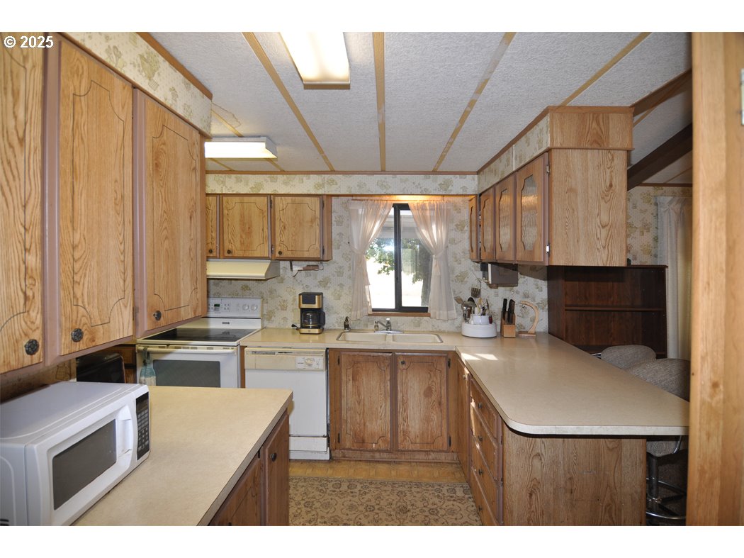 18385 South Springwater Road Estacada, OR 97023 - Photo 14 of 22 a kitchen with a sink a stove a refrigerator and cabinets