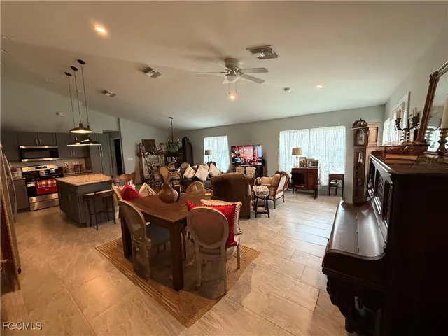 a living room with furniture kitchen view and a flat screen tv