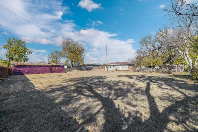 a view of dirt yard with a table and chairs