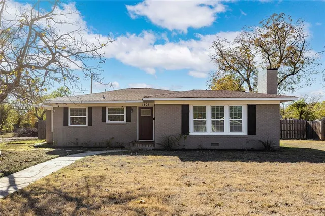a front view of a house with a yard covered with snow