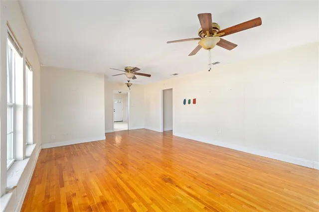 a view of a big room with wooden floor closet and windows