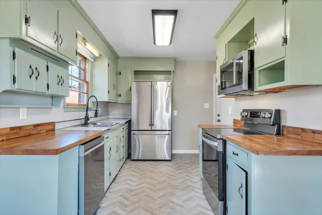 a kitchen with stainless steel appliances granite countertop a sink stove and refrigerator