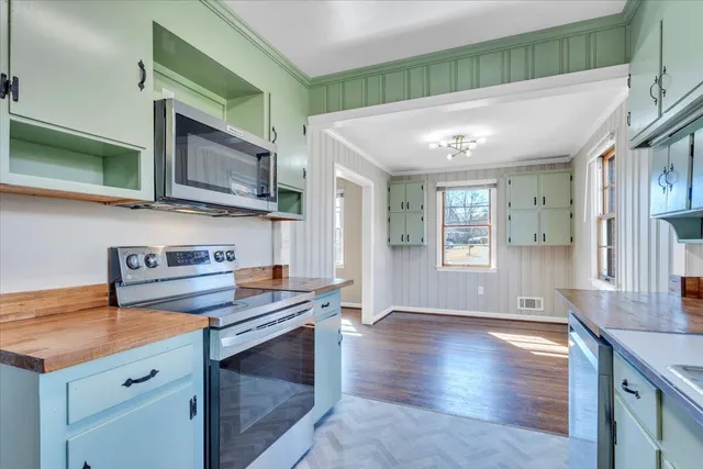 a kitchen with stainless steel appliances granite countertop a stove a sink and a microwave