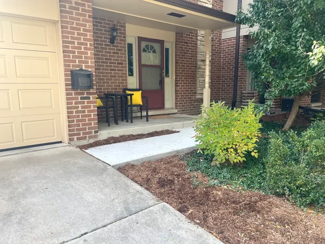 a view of a house with potted plants and a yard