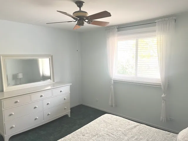 a bedroom with a bed and a mirror on dresser